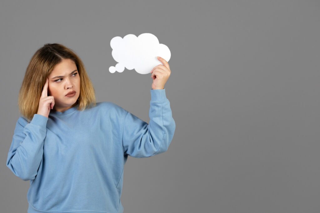 Mujer joven sosteniendo una burbuja de pensamiento con espacio de copia